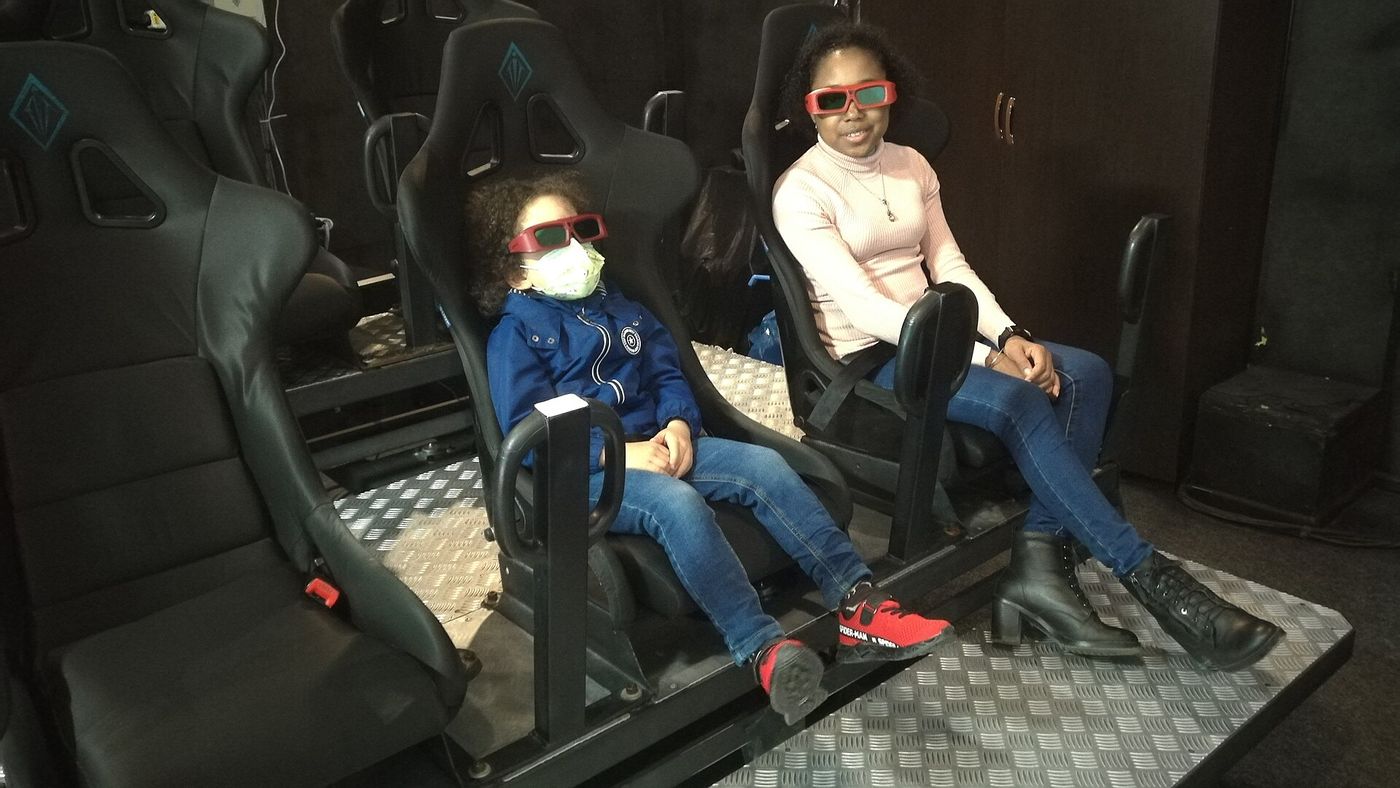 A parent and child in 3D glasses in a 7D cinema